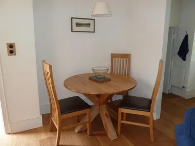 a wooden table with two chairs and a bowl on it at Bronfelin & Troed-y-Rhiw Holiday Cottage in Llanwrtyd Wells