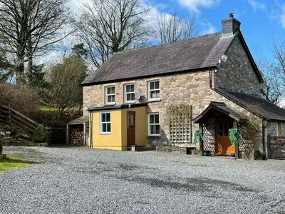 an old stone house on a gravel driveway at Rhiwddu Barns in Llangadog