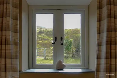 a window with a teddy bear sitting in front of it at Rhiwddu Barns in Llangadog