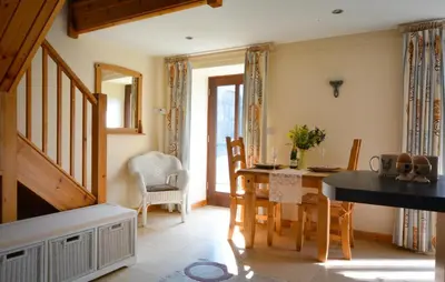 a kitchen and dining room with a table and chairs at Rhiwddu Barns in Llangadog