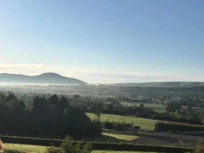 a view of a field with mountains in the distance at Gaer Fawr Barns in Guilsfield