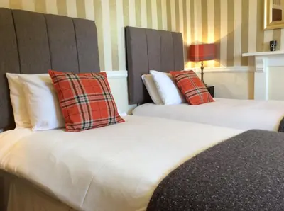 two beds sitting next to each other in a hotel room at Aberllynfi Riverside Guest House in Glasbury