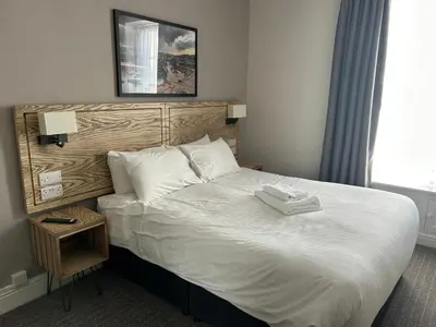 a hotel room with a bed with two towels on it at Hotel Penwig in New Quay