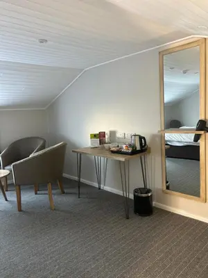 a room with a table and a mirror and a bed at Hotel Penwig in New Quay