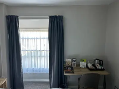 a desk in a room with a window with curtains at Hotel Penwig in New Quay
