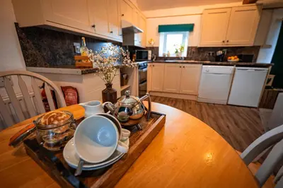 a kitchen with a wooden table with dishes on it at Irfon Cottage in Builth Wells