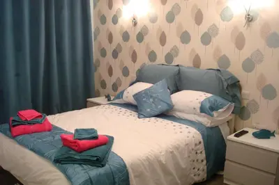 a bedroom with a bed with two towels on it at Talybont B&B Aberystwyth in Talybont
