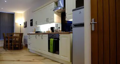 a kitchen with white cabinets and a stove top oven at Mid Wales Holiday Lets, Rhayader in Rhayader