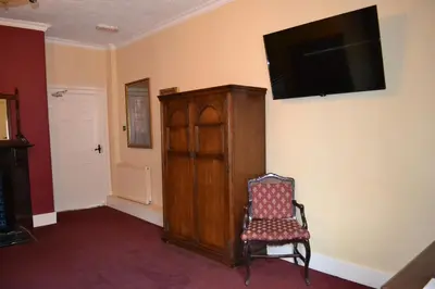 a room with a chair and a television on a wall at The Red Lion in Llangadog