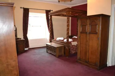 a bedroom with a canopy bed and a window at The Red Lion in Llangadog