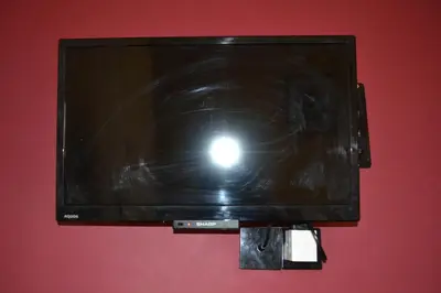 a black tv hanging on a red wall at The Red Lion in Llangadog