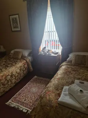 a small room with two beds and a window at The Red Lion in Llangadog