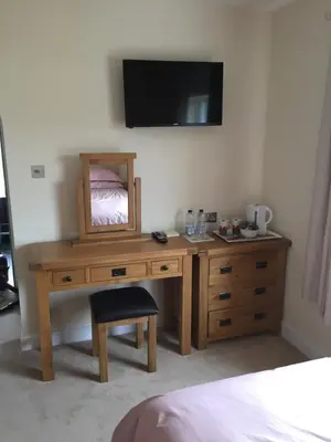 a wooden desk with a mirror and a tv on a wall at Bryn Derwen in Rhayader