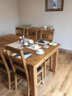 a wooden table with chairs and a dining room at Bryn Derwen in Rhayader