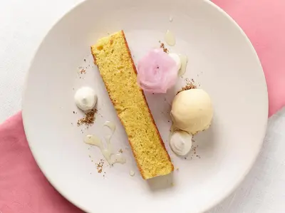 a white plate with a piece of cake and ice cream at Riverside Inn, Aymestrey in Aymestrey