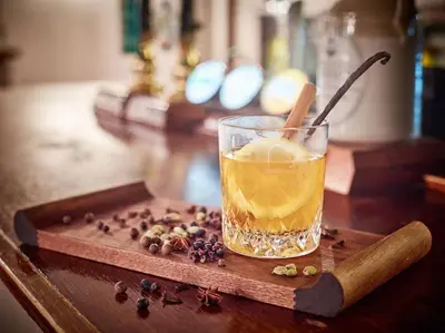 a glass of drink on a wooden tray with coffee beans at Riverside Inn, Aymestrey in Aymestrey
