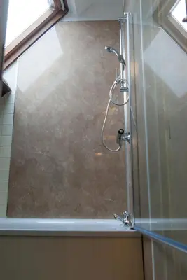 a shower with a glass door in a bathroom at The Dragon Hotel in Montgomery