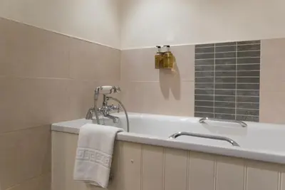 a bathroom with a bath tub with a shower at The Dragon Hotel in Montgomery