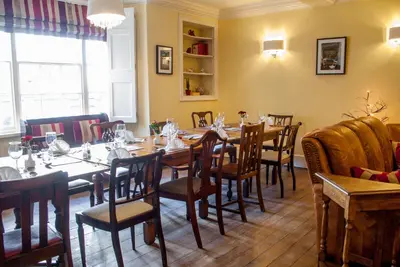 a dining room with wooden tables and chairs at The Dragon Hotel in Montgomery