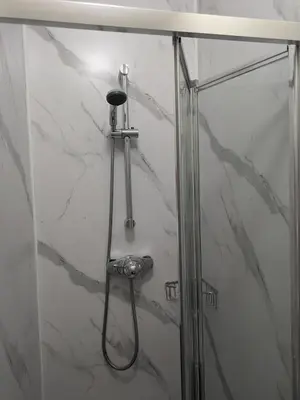 a shower in a bathroom with a glass door at Llangollen Hostel - Book Whole Room - Self Catering Facilities in Llangollen