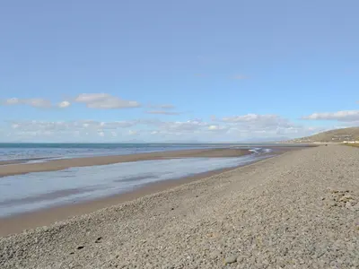 a sandy beach with the ocean in the background at Fairlawns in Fairbourne