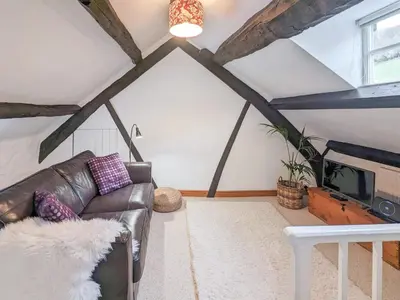 a living room with a leather couch and a tv at Ty'n Y Ffordd in Llanymawddwy