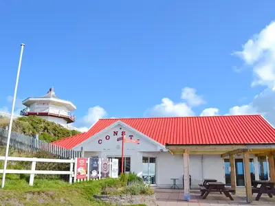 a building with a lighthouse on top of a hill at Cliff Railway Apartment in Aberystwyth