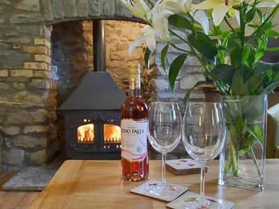 a bottle of wine sitting on a table with two wine glasses at Gorsddu in Llanwrthwl