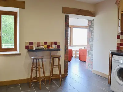 a kitchen with two stools and a counter in a room at Gorsddu in Llanwrthwl