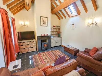 a living room with a couch and a fireplace at Yr Efail - Hw7387 in Llanymawddwy