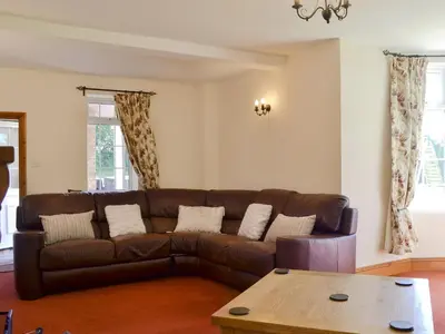 a living room with a brown couch and a table at Cefnaire in Newtown