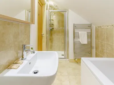 a white bathroom with a sink and a tub at Cwmhyfryd in Llanllwchaiarn