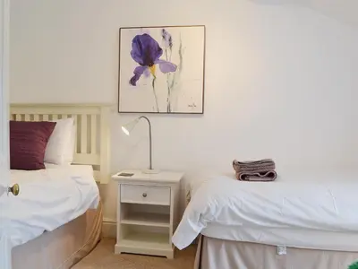 a bedroom with two beds and a lamp on a night stand at The Old Post Office in Myddfai