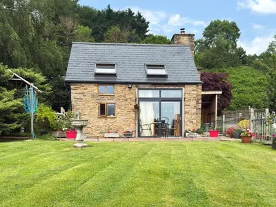 a small brick house with a lawn in front of it at Acorn Cottage in Croft