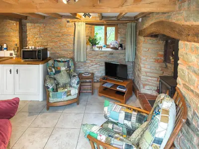 a living room with two chairs and a tv at Acorn Cottage in Croft