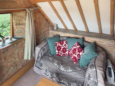 a couch in a tiny house with pillows on it at Acorn Cottage in Croft