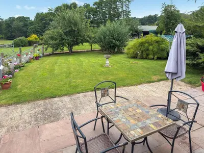 a table and chairs and an umbrella on a patio at Acorn Cottage in Croft