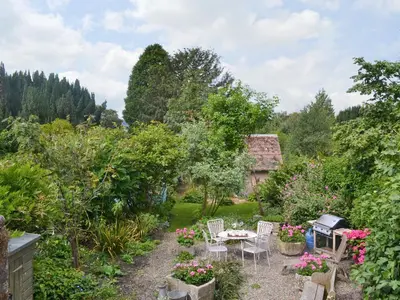 a garden with a table and chairs and trees at Friary Cottage in Ludlow
