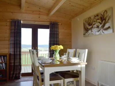 a dining room with a table and chairs and a window at Callow Lodge in Meadowtown