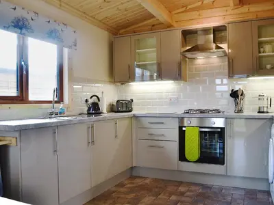 a kitchen with white cabinets and a green towel on the oven at Callow Lodge in Meadowtown