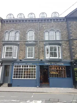 a large brick building with a sign in front of it at The Tilman in Barmouth