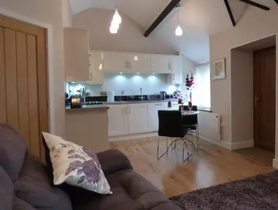 a living room with a couch and a kitchen at Becws Clyd in Trawsfynydd
