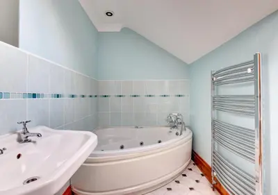 a white bathroom with a tub and a sink at Beudy Bach in Lampeter