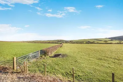 a field with a fence and benches in a field at 3 Bed in Aberystwyth oc-76692 in Llanilar
