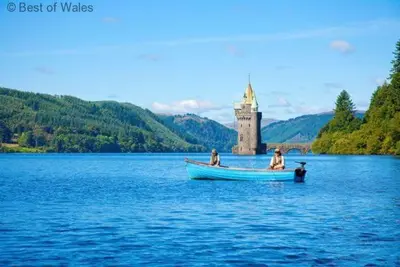 three people in a boat on a lake with a castle at 1 Bed in Welshpool oc-75714 in Meifod