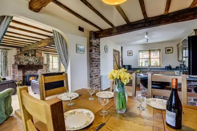 a dining room with a table with a bottle of wine at 2 Bed in Welshpool oc-75703 in Meifod