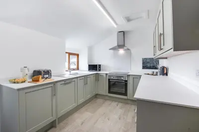 a kitchen with gray cabinets and white counter tops at 2 Bed in Aberdyfi oc-78258 in Pennal