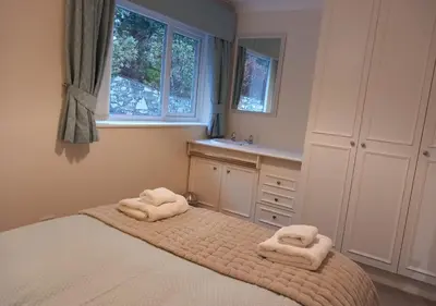 a bedroom with two towels on top of a bed at Gerddi'r Coed in Dolgellau