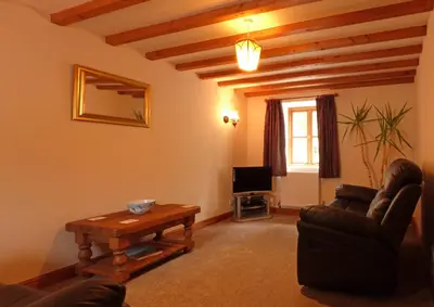 a living room with a couch and a table at Granar Gynolwyn in Abergynolwyn