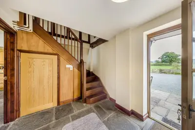 a hallway with a wooden door and a staircase at 4 Bed in Builth Wells oc-39473 in Builth Wells